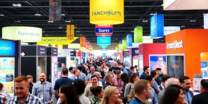 Crowded franchise expo with colorful booths and attendees.